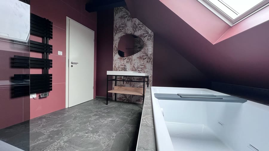 Salle de bain réalisée — baignoire et mur prune sous combles